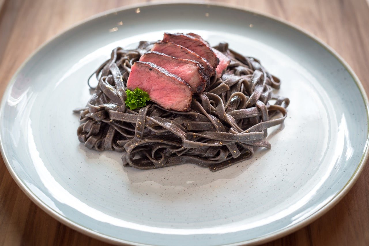 Büffel Rib-Eye Caveman Style Direkt in der Glut gegrillte Rib-Eye Steaks vom argentinischen Büffel auf Sepia Pasta. Mit dem Büffel Rib-Eye Caveman Style beeindruckt man auch verwöhnte Gaumen! ZUTATEN für 3-4 PERSONEN: 2 Büffel Rib-Eye Steaks ca. 350g pro