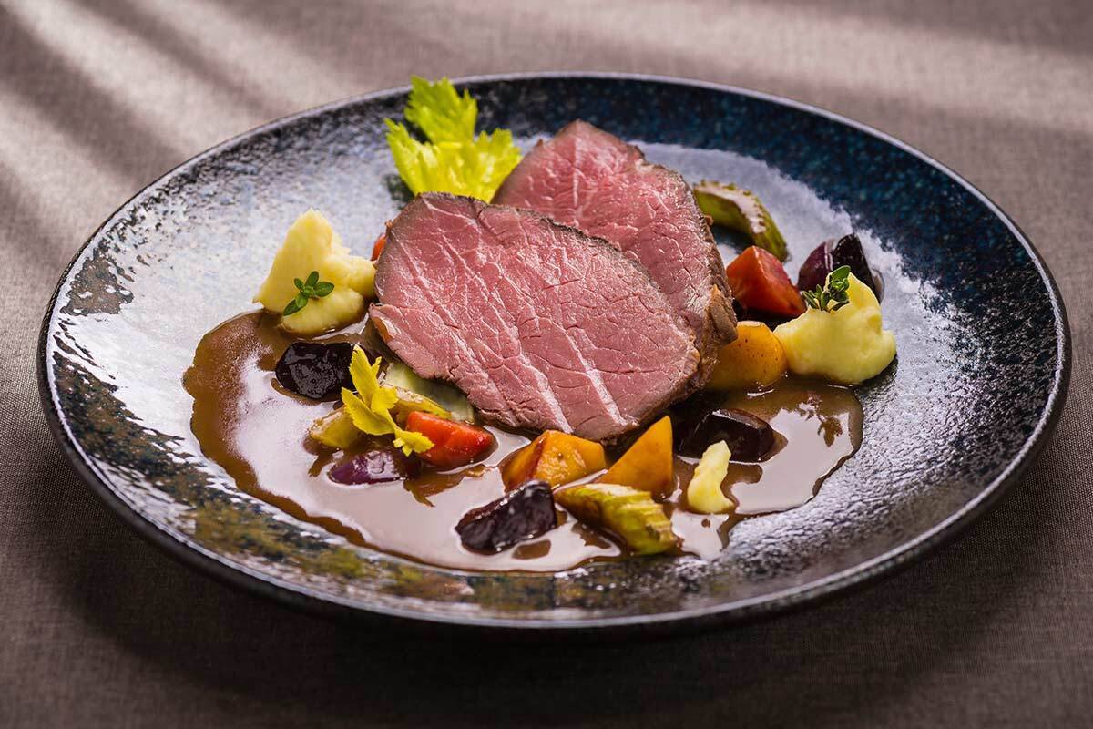 Pink boiled beef in balsamic sauce with braised vegetables